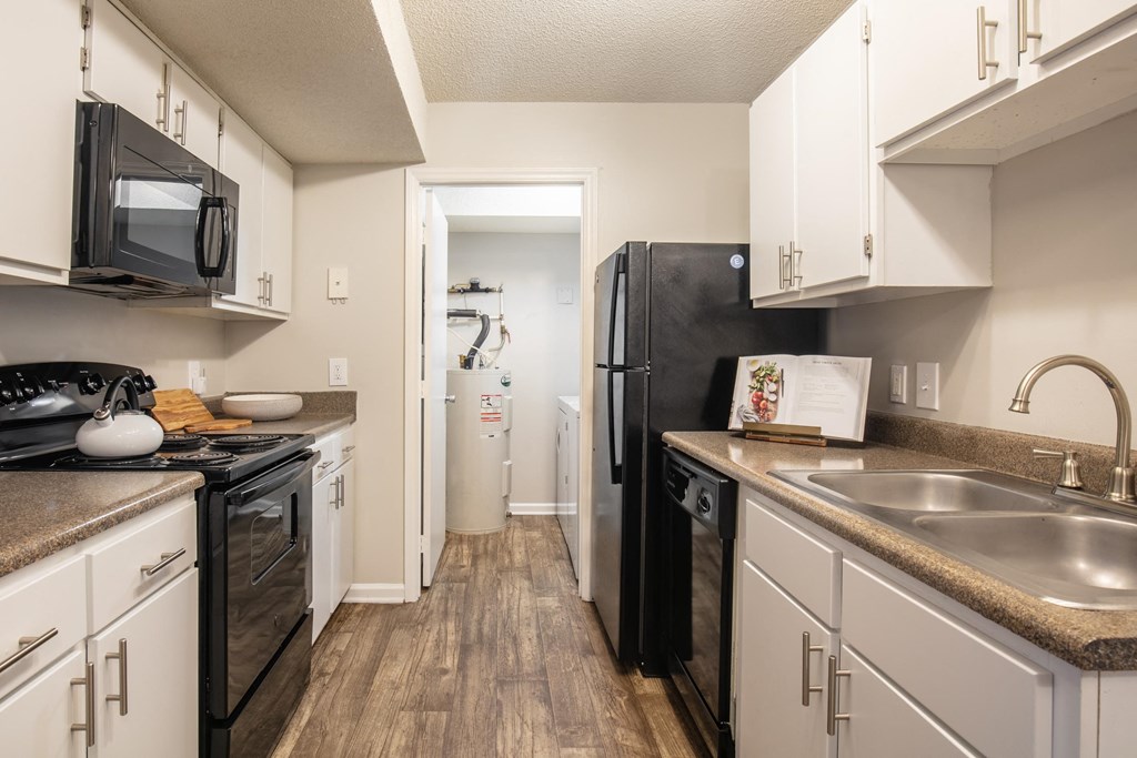 a kitchen with white cabinets and a black refrigerator
